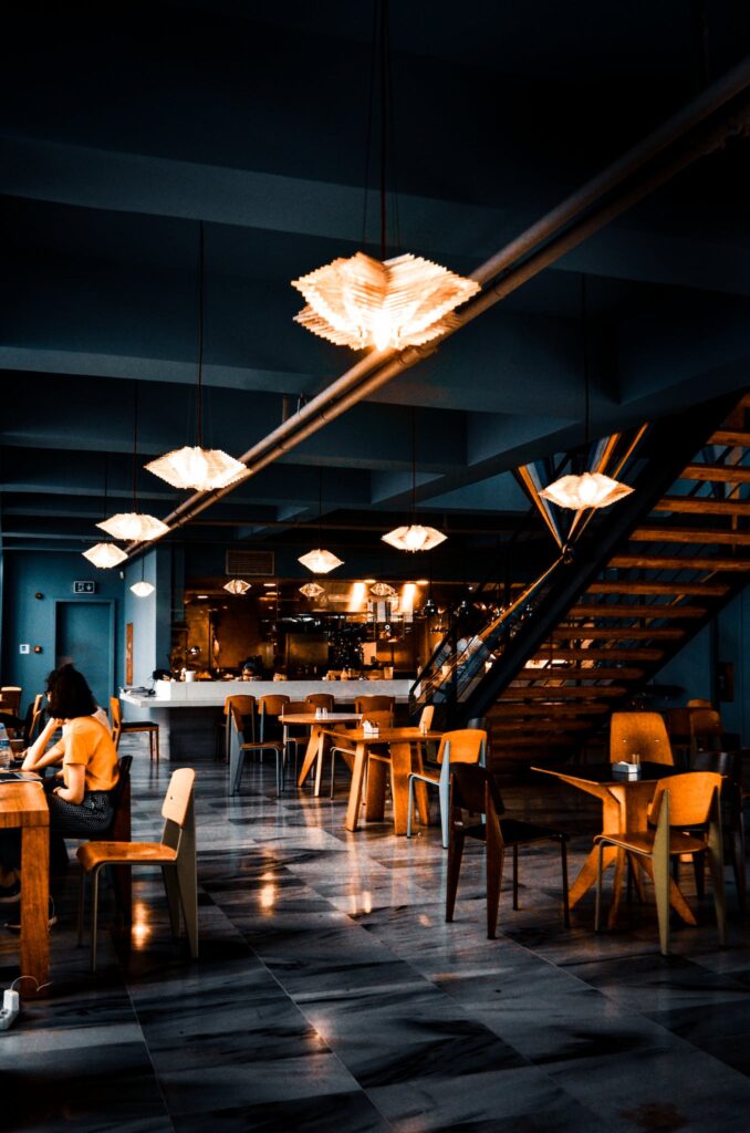 Trendy interior of cafe with creative lamps and wooden furniture